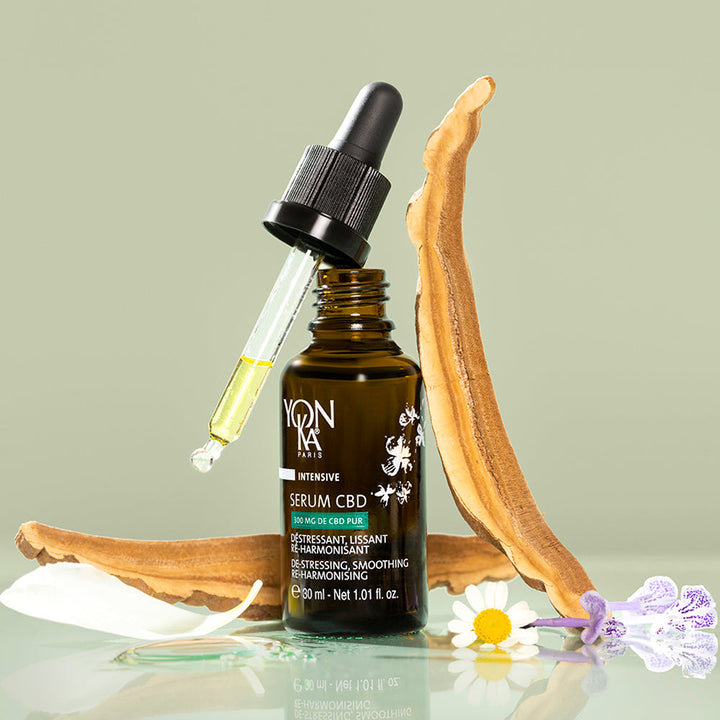 CBD serum bottle with dropper on a light green background